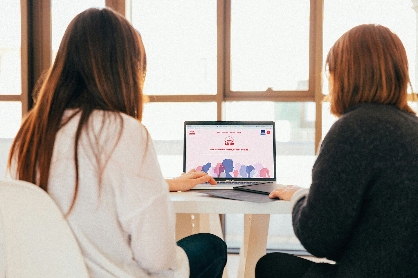 Website zwei Frauen sitzen am Laptop