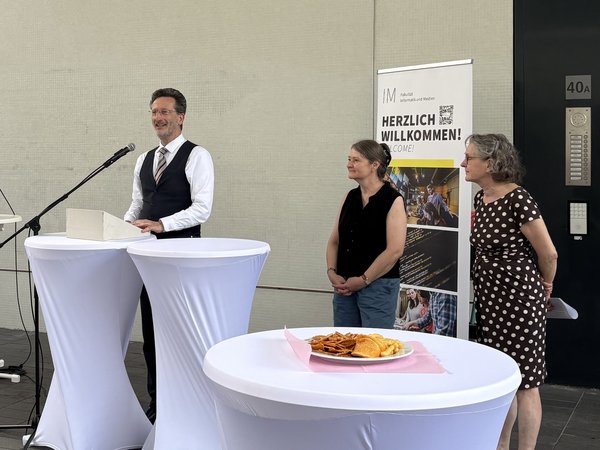 Prof. Dr.-Ing. Jean-Alexander Müller hält eine Rede zur Ausstellungseröffnung; daneben (v.l.n.r.): Dipl.-Des. Julia Plato, Prof. Dr. Gisela Weiß Der Rektor der HTWK begrüßt die Gäste zur Eröffnung der Ausstellungsreihe der Museologie vor der HTWK-Bibliothek.