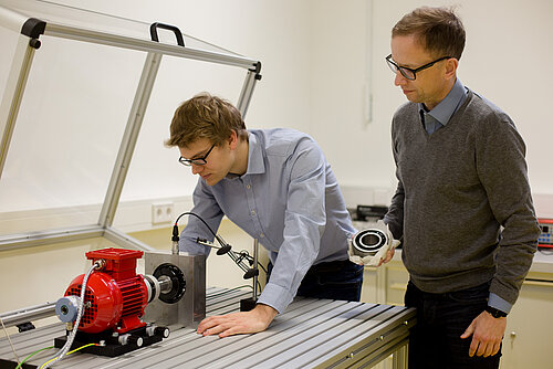 Forscherteam Industrielle Messtechnik Professor Mathias Rudolf und Mitarbeiter Maik Wolf am Prüfstand zur Schwingungsdiagnose.