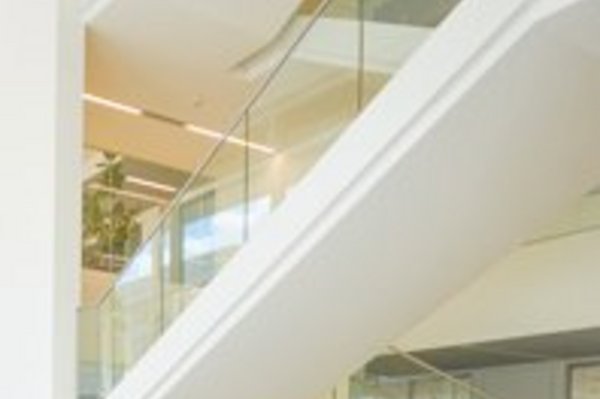 Vorraum mit Treppen im Nieper-Bau der HTWK Leipzig bei Tageslicht, davor der Schriftzug Aktuelles
