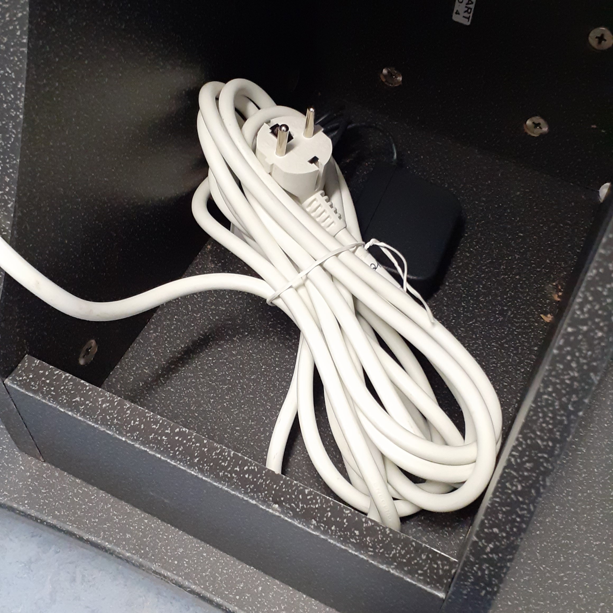 Ein weißer, aufgewickelter Schuko-Stecker.